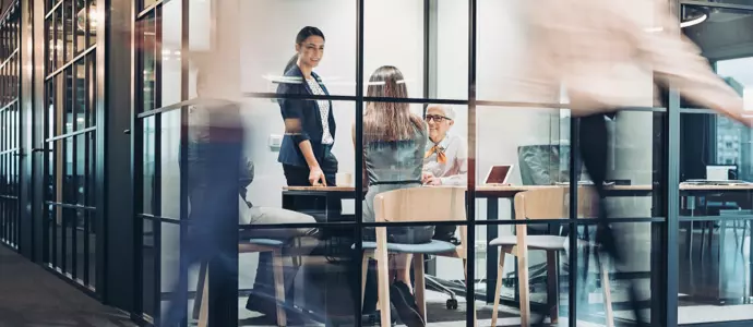 Busy office with people walking by and motion blur