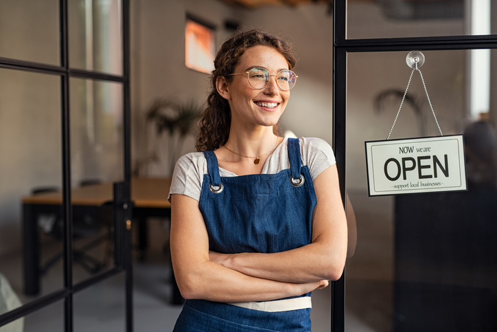 Woman standing proudly next to her small business