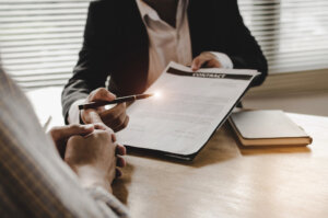 Breach Of Contract Lawyer Miami, FL - business man, legal consultants, notary or justice lawyer discussing contract document with customer client on desk in courtroom office, business, justice law, insurance and legal service concept