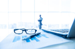 Shareholder Dispute Lawyer, Miami, FL - Focus on the things on the table. Blurred man near panoramic windows on background.