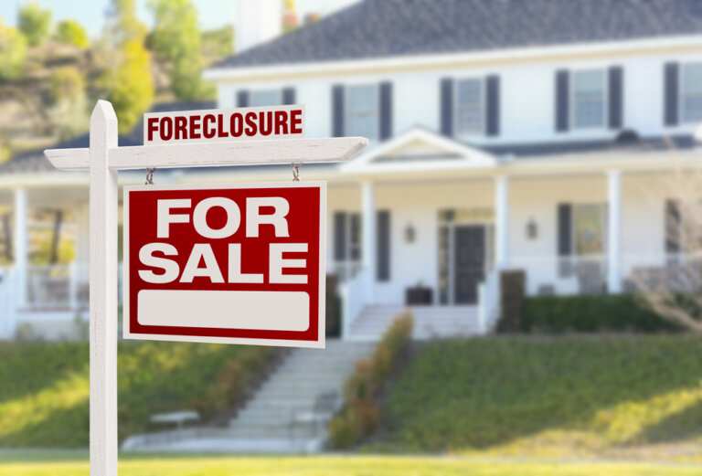 Taking Action When Facing Foreclosure - Foreclosure Home For Sale Real Estate Sign in Front of Beautiful Majestic House.