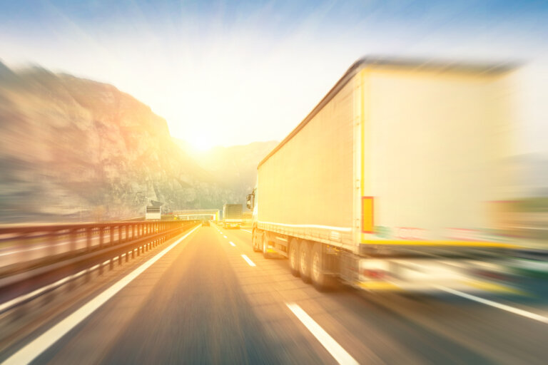 Safe Trucking Laws 2023 Generic semi trucks speeding on the highway at sunset - Transpor